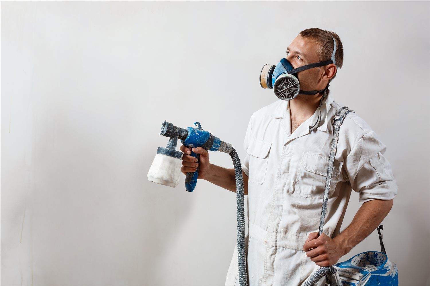 Spray technician applying a clean finish to an interior wall